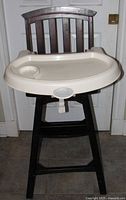 Front view of dark wood high chair with beige tray