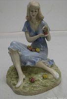 Front view of figurine showing pose, dress, roses and base