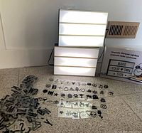 Two illuminated lightbox signs, USB cable, loose letter tiles, product box