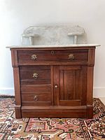 Front view of wooden dresser with marble top and backsplash