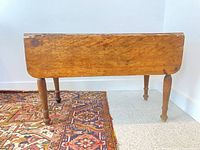 Table front view with leaf down showing turned legs and patina