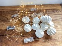 All five light strands coiled on tabletop showing lanterns and battery boxes