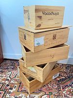 Stack of five branded wooden wine crates showing logos and unfinished wood construction