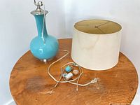 Lamp base, shade, and loose hardware on table