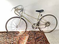 Full side view of cream Peugeot mixte road bicycle on rug
