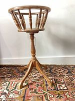 Full view of wooden spindle-back swivel plant stand showing pedestal and tripod legs