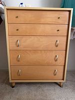 Front view showing five drawers, hardware, and overall finish