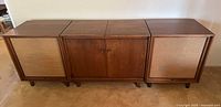 Front view of three-section walnut stereo console with speaker grilles