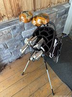 Full view of golf bag standing with clubs