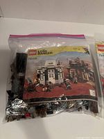 Bagged LEGO pieces with instruction booklet showing set 79109 cover
