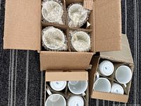 Three open cartons showing multiple mugs, each in cardboard divider and bubble-wrap