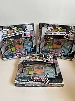 Three open Pokémon Black & White Bolt Strike & Blue Flare Poster Collection boxes front view