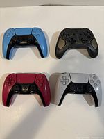Front view of four controllers showing button layouts and colors