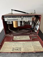 Rear view with cover open showing tube chassis, capacitor, wiring, schematic