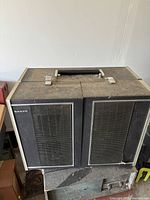 Front view of closed Sanyo reel-to-reel tape recorder showing speaker grilles and handle