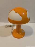 Front left view showing orange mushroom lamp with white clouds and cord