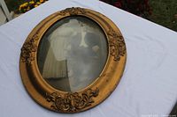 Front view of oval gold frame showing portrait and convex glass