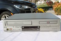 Front view showing VHS and DVD trays, control panel and branding