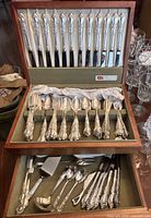 Chest with two tiers open showing knives, place settings, serving pieces