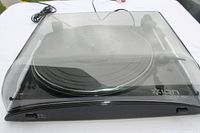 Overall view of ION Profile LP turntable with dust cover closed and attached cables