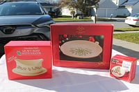 Three boxed holiday-themed porcelain items displayed