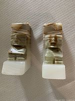 Front view of the pair showing carved figures and bases