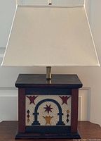 Front view of lamp showing punched tin panel with arch and star motifs