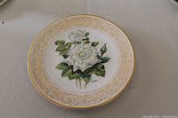 Front of plate showing rose design and gold border