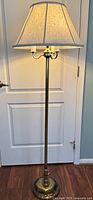 Full view of brass floor lamp with shade