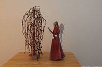 Willow tree sculpture and angel figurine side by side on table