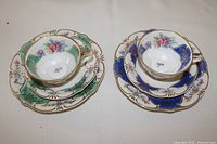 Two complete snack sets with cups, saucers and plates displayed