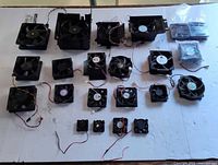 Overall layout of the entire lot showing all cooling fans grouped by size including bagged laptop fans