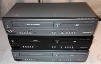 Front view of three stacked Magnavox DVD/VCR units