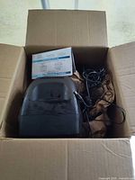 Open box showing Swann CRT monitor, bundled cables, and manual