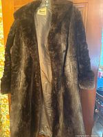 Full front view of brown mink fur coat on hanger