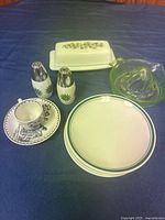 Group shot showing all items: butter dish, juicer, shakers, souvenir cup & saucer, stack of green-banded plates
