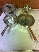 Overview of all four pans with lids on tabletop