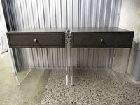 Both nightstands front view showing acrylic legs, drawer fronts