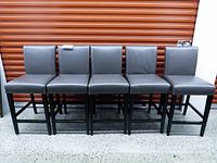 Front view of five charcoal upholstered counter stools in a row