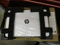 Laptop wrapped in plastic with foam inserts