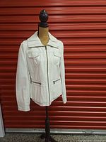 Front view of ivory faux leather Ness jacket on mannequin showing zipper closure and pockets