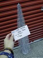 Hand holding silver wire tinsel cone tree with size note
