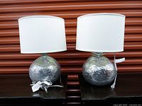 Both lamps side by side showing bases wrapped for protection and drum shades