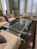 Top view of square two-tier glass coffee table among surrounding seating