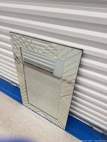 front view of rectangular mirror leaning against wall