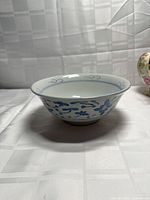 Side view of porcelain bowl showing exterior blue floral design and flared rim