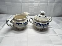 Creamer left, lidded sugar bowl right, front view