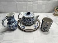 Front view of teapot, creamer, cup, and tray