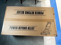 Top of sealed EGO mower box with slogan and outline graphic