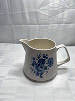 Front view showing blue floral motif, handle, spout